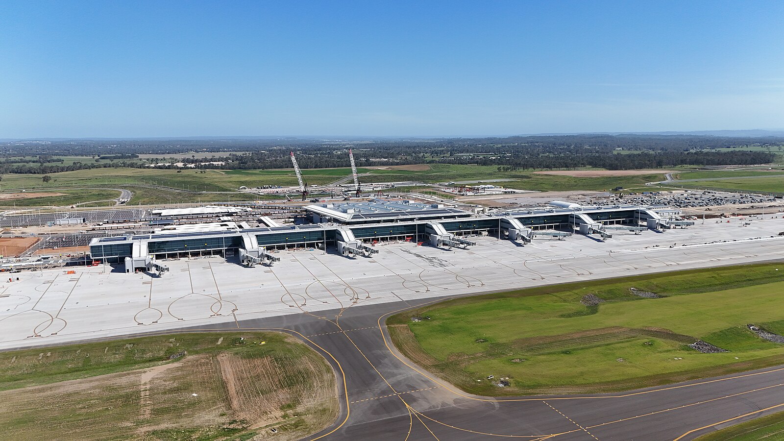 WSI_airport_terminal_2025 Aerial view of Western Sydney Airport, showing runways, terminals, and surrounding landscape.