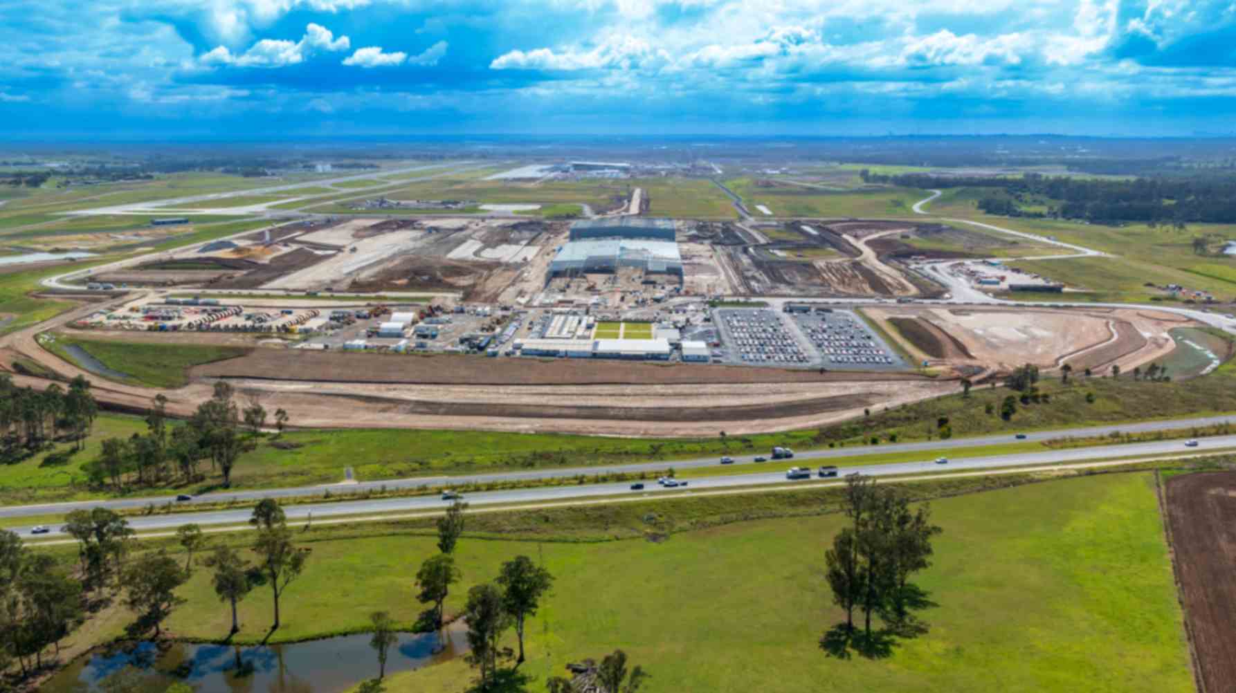 Aerial view of Western Sydney Airport, showing runways, terminals, and surrounding landscape.